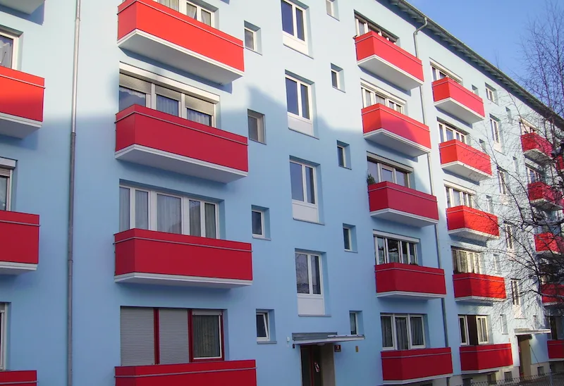 Rote Balkonbrüstungen an einem Wohngebäude